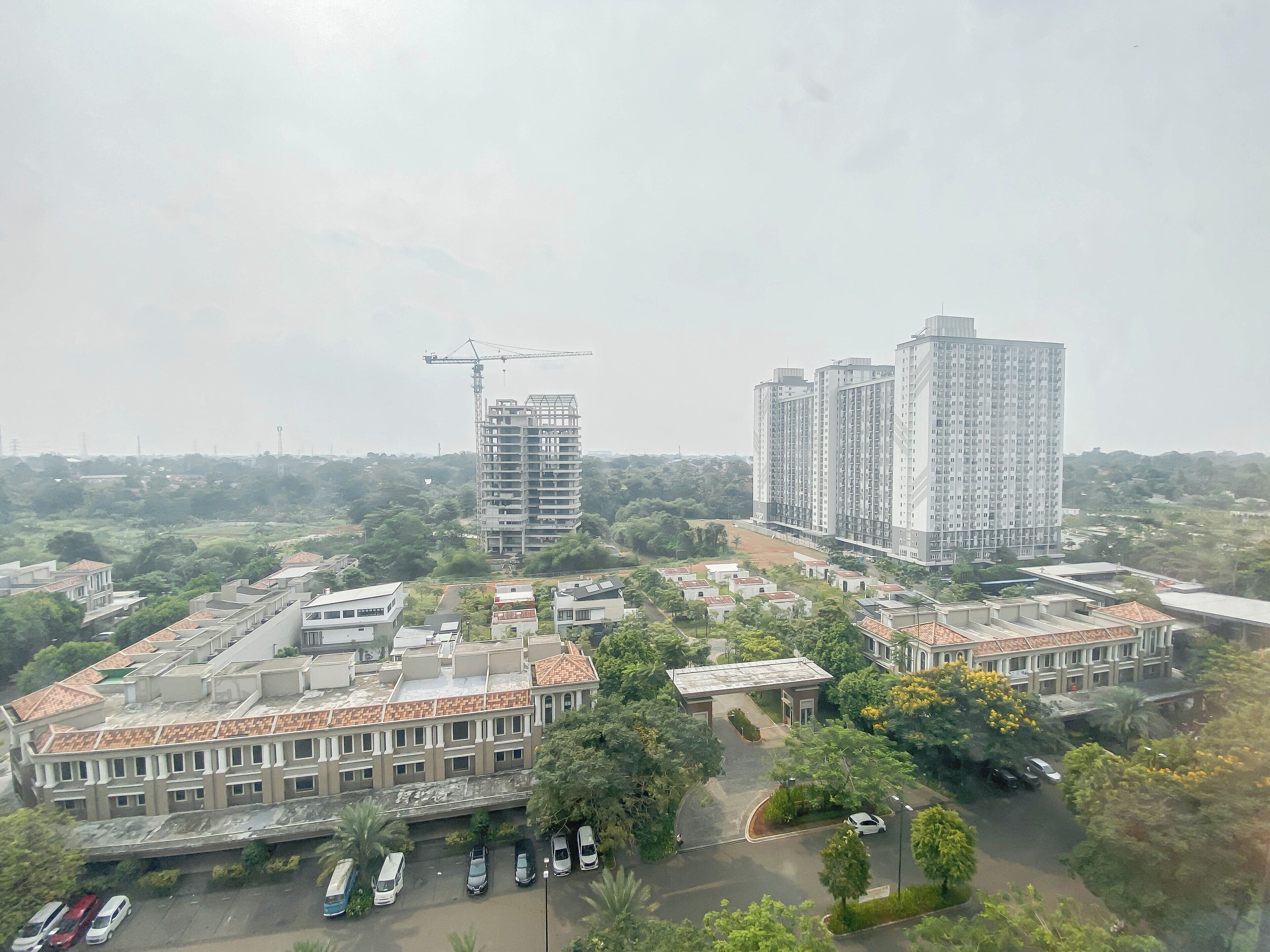 A residential area with high-rise buildings, a construction site, and a parking lot.