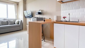 Une cuisine moderne avec des armoires blanches, un plan de travail en bois et un four à micro-ondes encastré.
