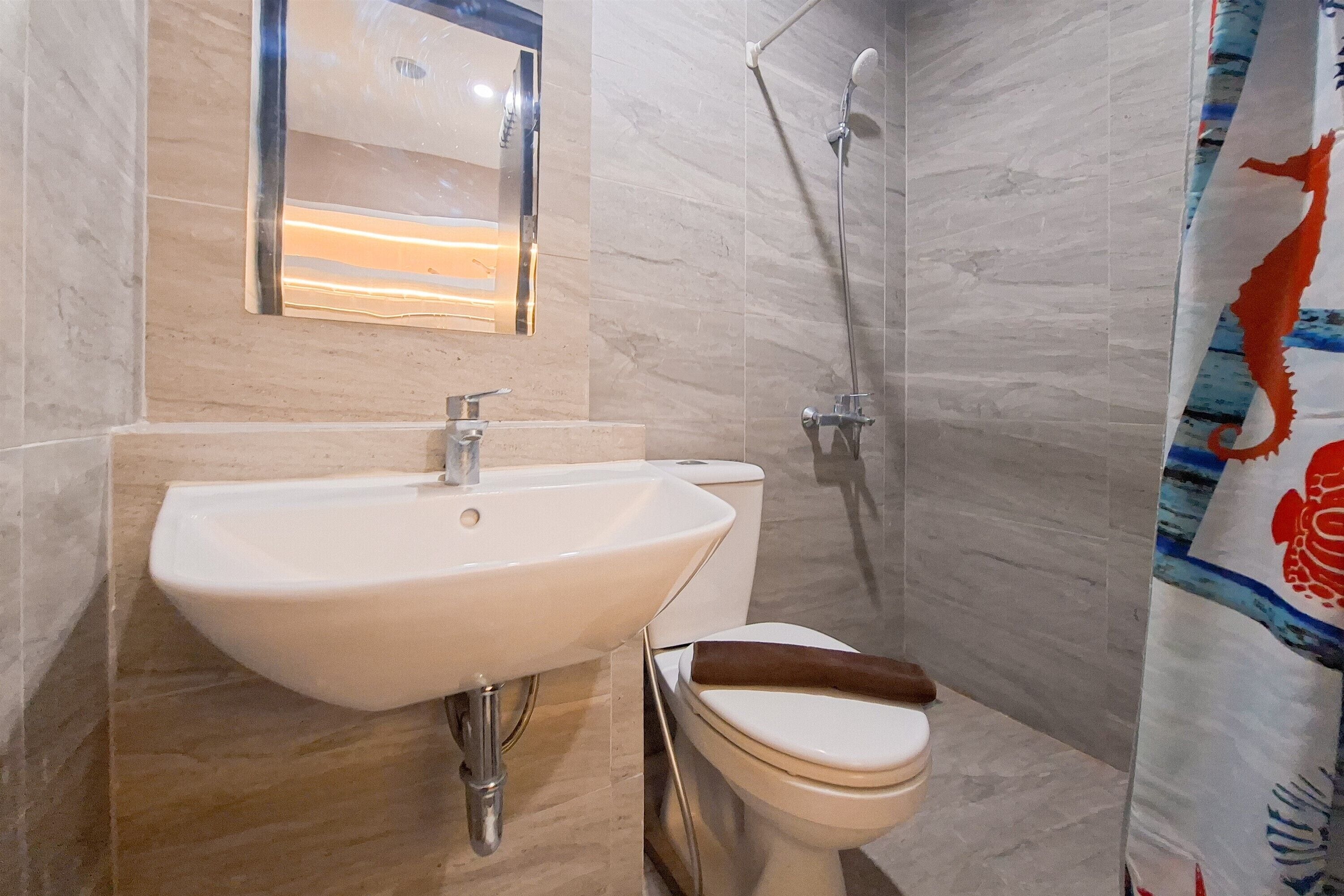 A bathroom with a white sink, toilet, and shower.