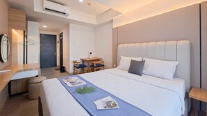 Une chambre d’hôtel moderne, dotée d’un grand lit, d’un bureau et d’une chaise.