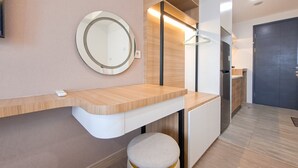 Une salle de bain moderne avec un meuble-lavabo en bois, un miroir rond et un petit tabouret.