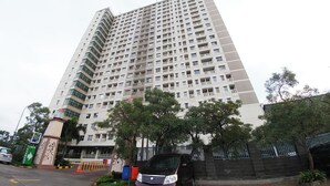 A high-rise building with multiple balconies, a parking area, and a sign indicating a tower named Everest. - Comfortable 1Br At Belmont Residence Puri Apartment (Jakarta)