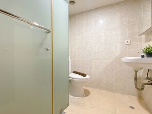 Ein Badezimmer mit Toilette, Waschbecken und Duschbereich.
