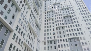 A high-rise building with a grid of windows and balconies. - Basic Look Studio Near Bekasi Station At Patraland Urbano Apartment (Bekasi)