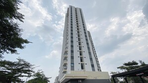 A tall, modern building with multiple floors and balconies. - Studio Apartment Jkt Living Star Near Citimall Cimanggis (Jakarta)