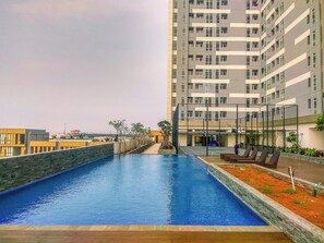 A swimming pool with a view of a high-rise building in the background.
