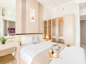 A hotel room with a bed, bedside table, chair, and a wardrobe.