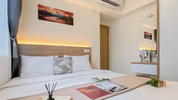 Habitació d'hotel amb un llit, una taula de nit amb safata, un vas i una revista.