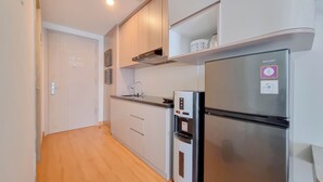 Una cocina moderna con electrodomésticos de acero inoxidable, armarios blancos y suelo de madera.