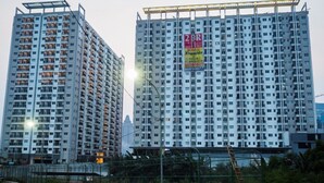 Two high-rise residential buildings with balconies, a construction site in the foreground, and a street with a fence and a ladder. - Spacious Studio At Signature Park Grande Apartment (Jakarta)