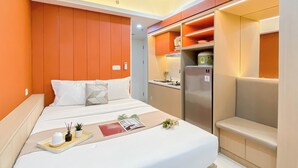 A modern hotel room with a bed, bedside table, and a built-in wardrobe. - Strategic Studio At Apartment Springlake Summarecon Bekasi (Bekasi)