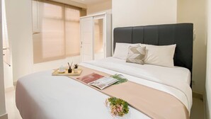 Ein Schlafzimmer mit einem Bett, einem Nachttisch und einem Fenster mit Jalousien.