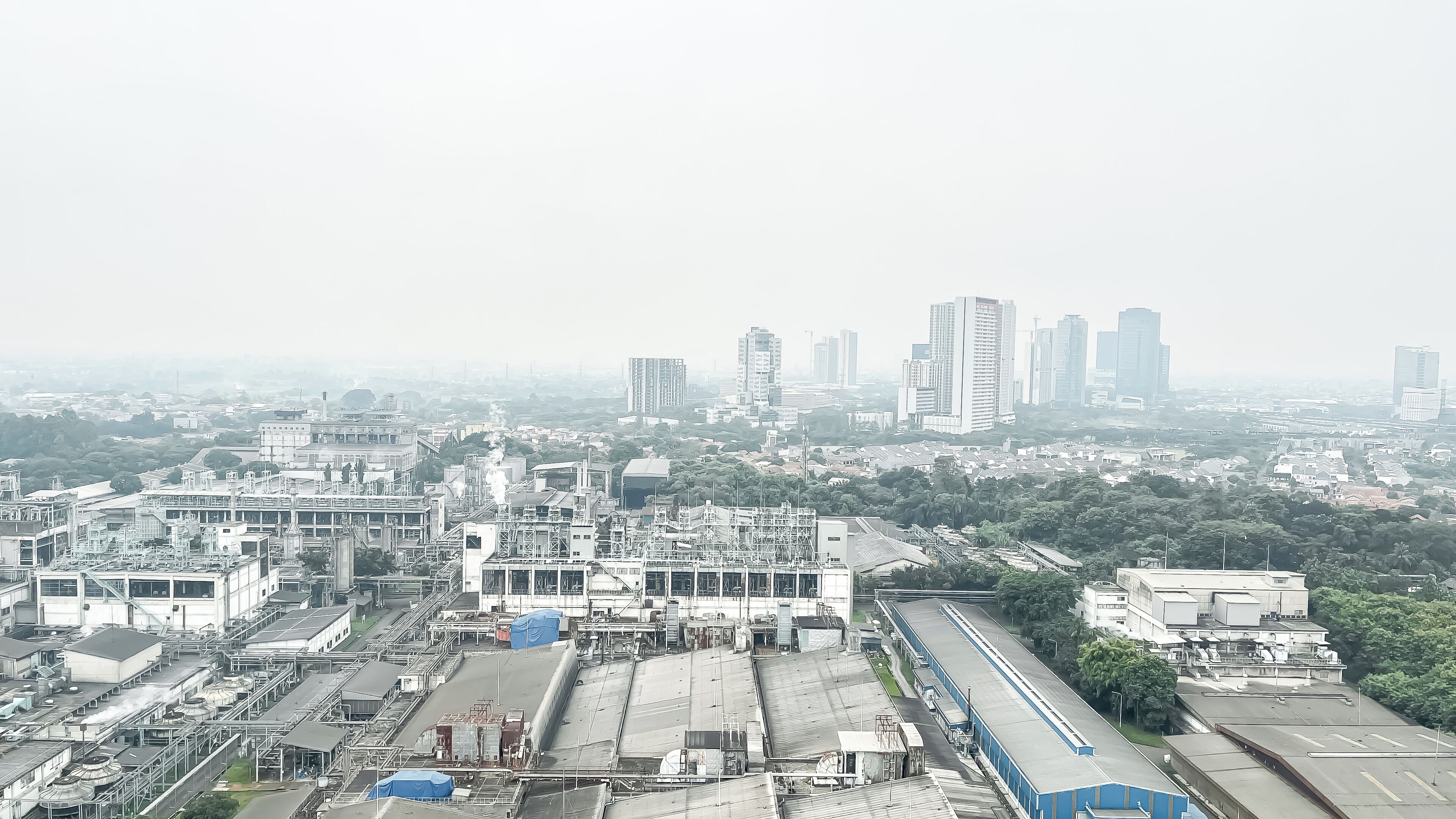 An industrial area with large buildings, a train track, and a mix of residential and commercial structures.