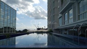 Un hôtel moderne doté d’une piscine, de grandes fenêtres et offrant une vue sur un ciel dégagé.