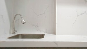Une cuisine dotée d’un évier en acier inoxydable et d’un robinet moderne.