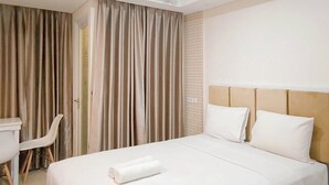 Une chambre d’hôtel avec un lit, un bureau et une chaise.