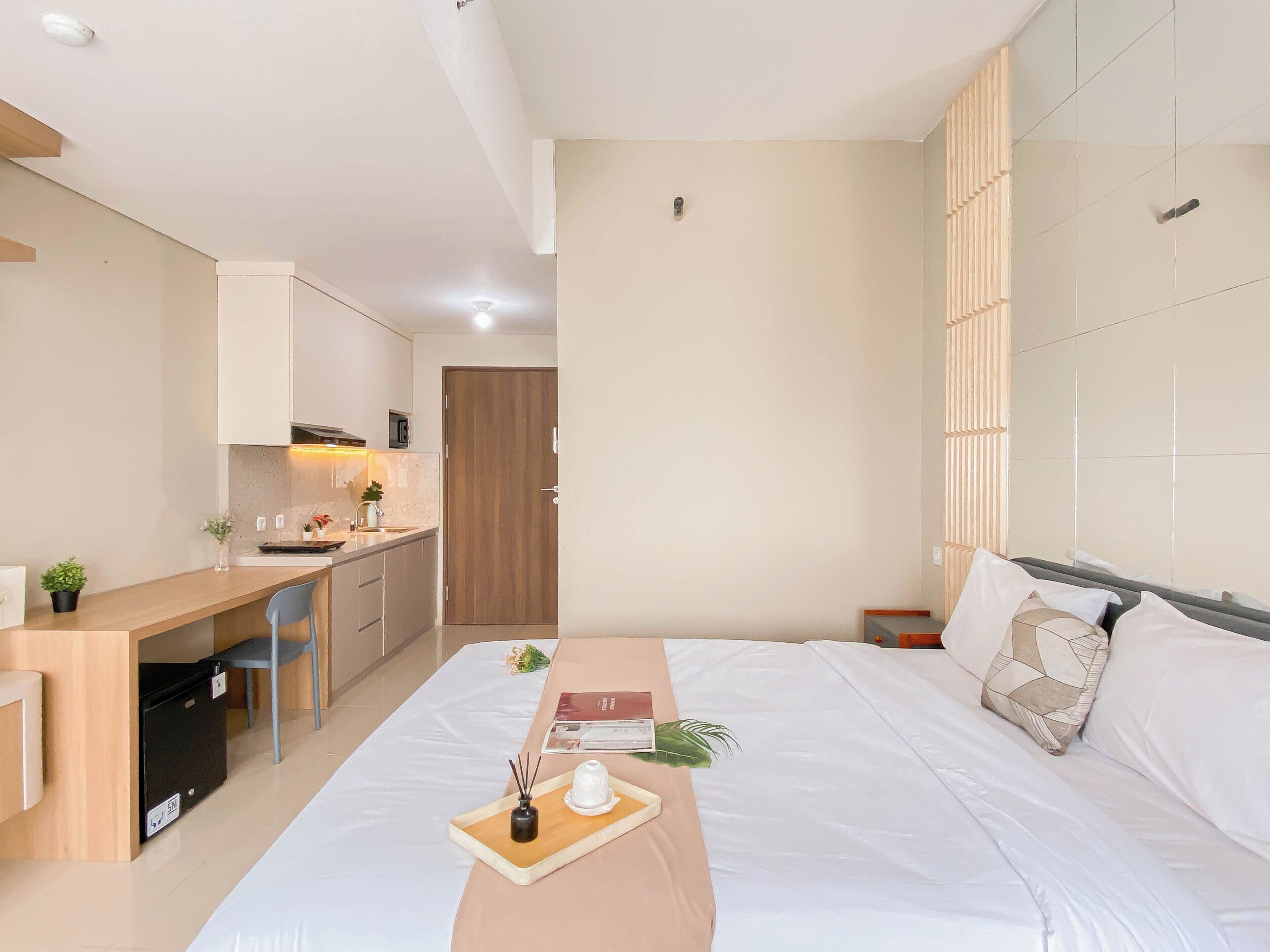 Une chambre d’hôtel moderne équipée d’un lit, d’une table de chevet et d’une kitchenette.