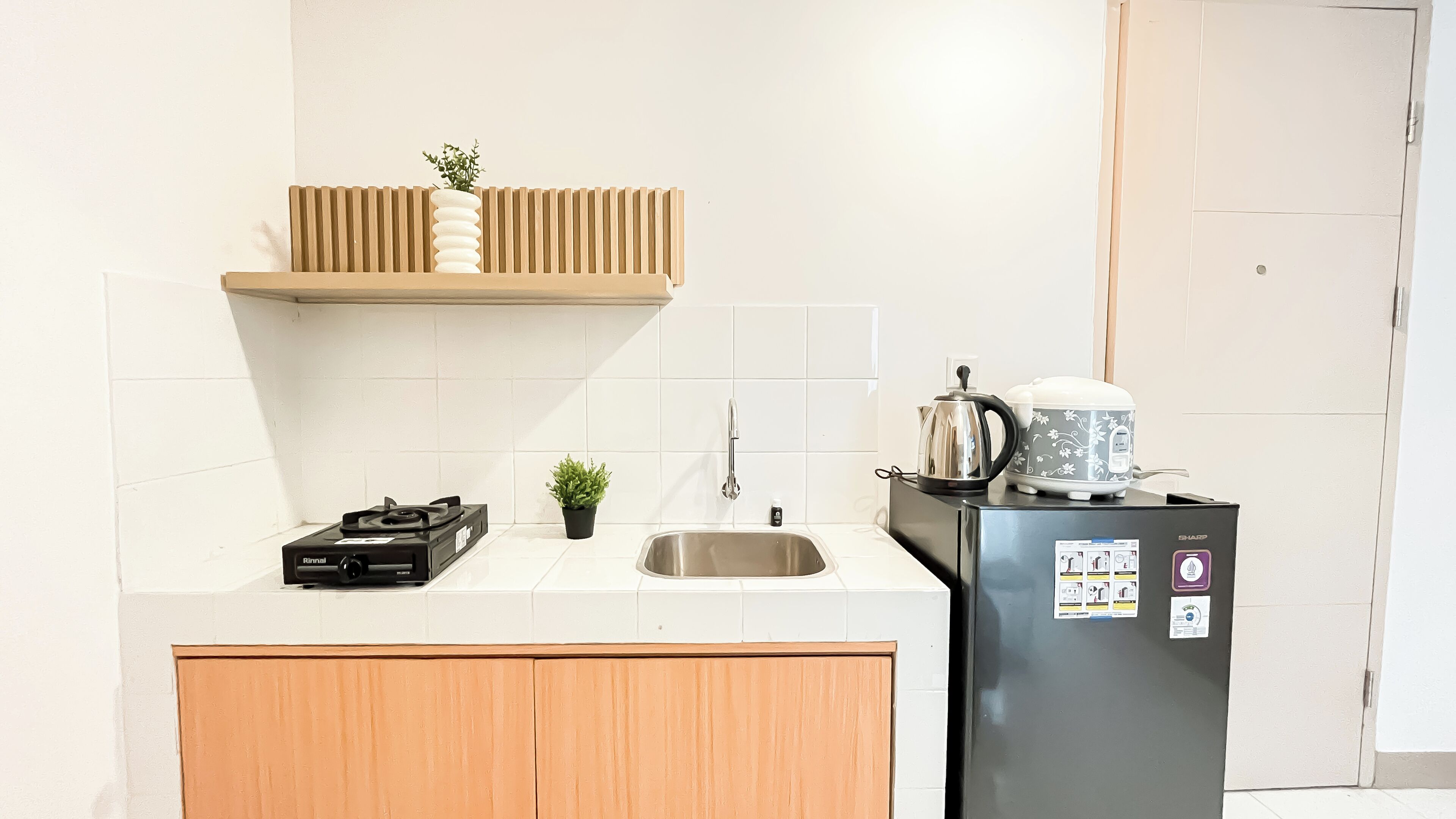 Une cuisine équipée d’une cuisinière à gaz, d’un évier et d’un réfrigérateur.
