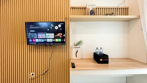 Een flatscreen televisie bevestigd aan een houten muur, met een streamingdienst interface en diverse content opties.