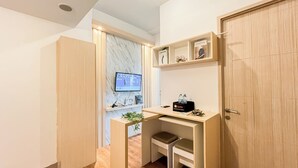 A compact room with a desk, a television, and a wardrobe. - Modern 2Br At Apartment Tokyo Riverside Pik 2 Near Tokyo Hub (Teluknaga)