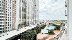 A high-rise residential building with a rooftop pool and surrounding greenery. - Modern 2Br At Apartment Tokyo Riverside Pik 2 Near Tokyo Hub (Teluknaga)