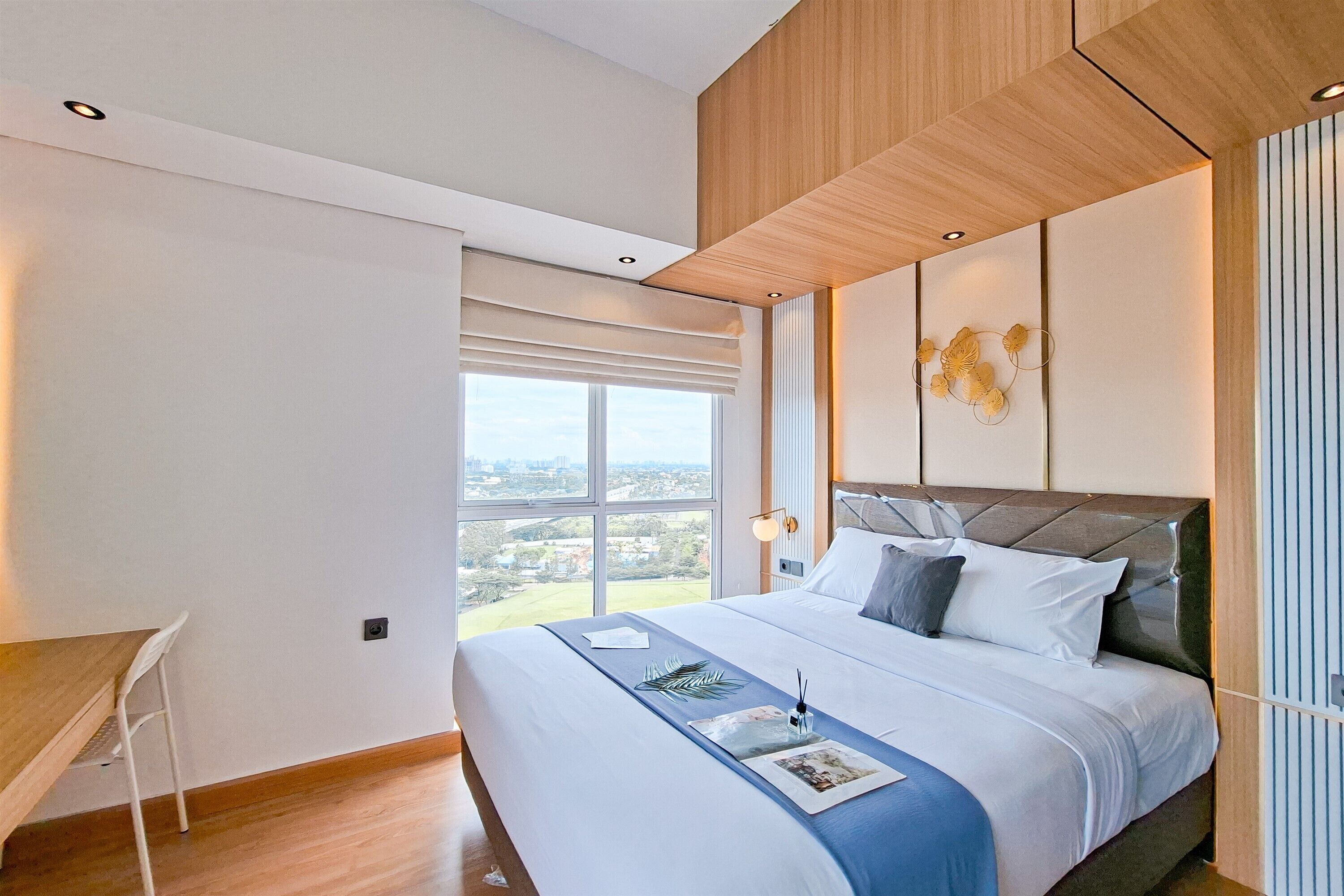 Un dormitorio moderno con una cama grande, un escritorio y vistas a la ciudad.