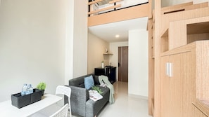 Eine moderne Wohnung mit Schlafzimmer im Loft-Stil, einem Essbereich mit Tisch und Stühlen sowie einem Wohnzimmer mit Sofa und Couchtisch.