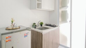 Una cocina compacta con refrigerador, pileta y cocina a gas.