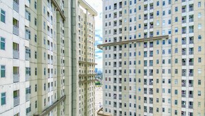 Un edificio residencial de gran altura con varios balcones y un patio central con juegos infantiles.