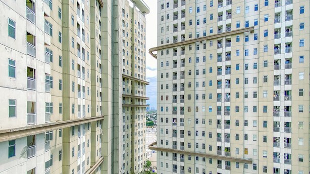 A high-rise residential building with multiple balconies and a small playground area. - Affordable Price 1Br Apartment At Vittoria Residence (Jakarta)