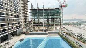 Un edificio de gran altura en construcción con una piscina al frente.