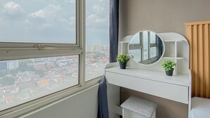 A room with a large window, a vanity with a mirror, and two potted plants. - Standard 2Br Near Station At Nifarro Park Apartment (Jakarta)