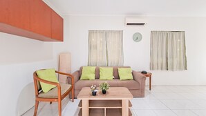 A modern living room with a sofa, two chairs, a coffee table, and a small side table. - Modern 4Br Apartment At Guest House Vanya Park (Pagedangan)