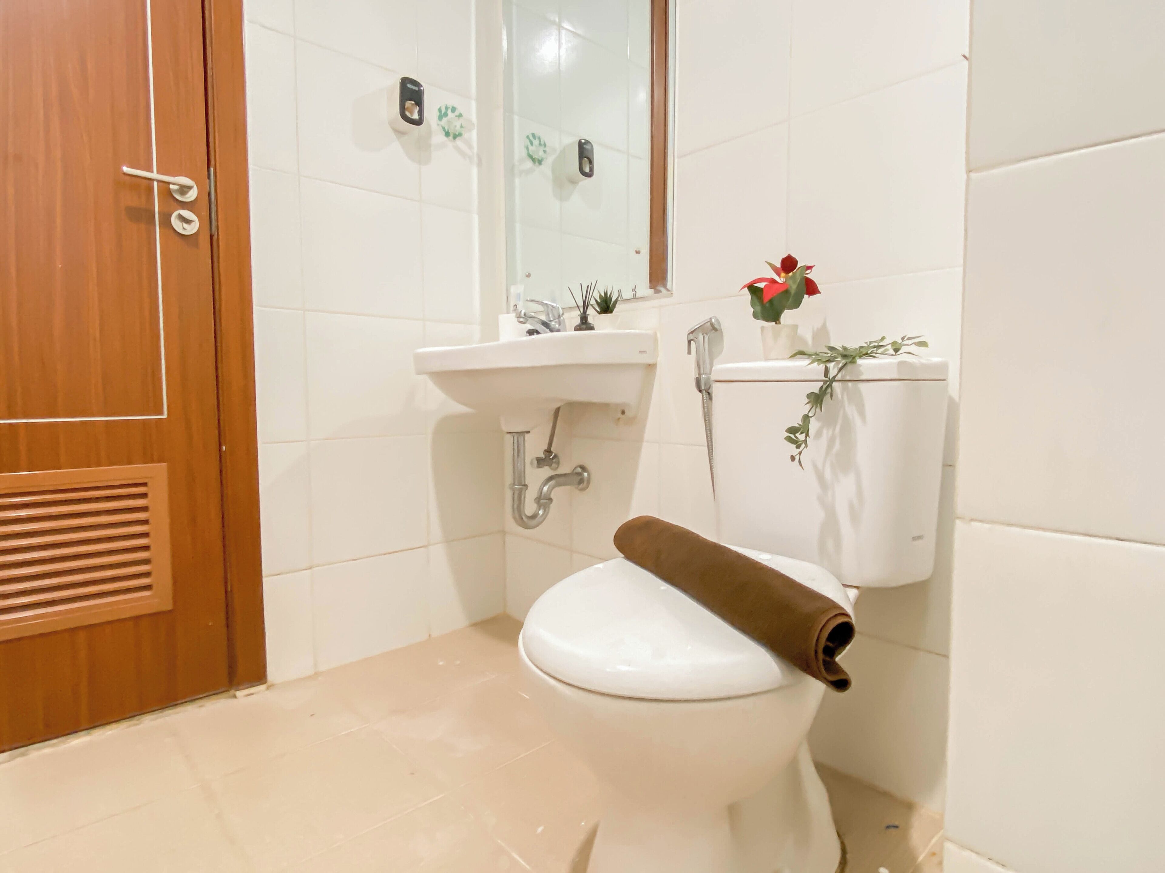 A bathroom with a toilet, sink, and mirror.