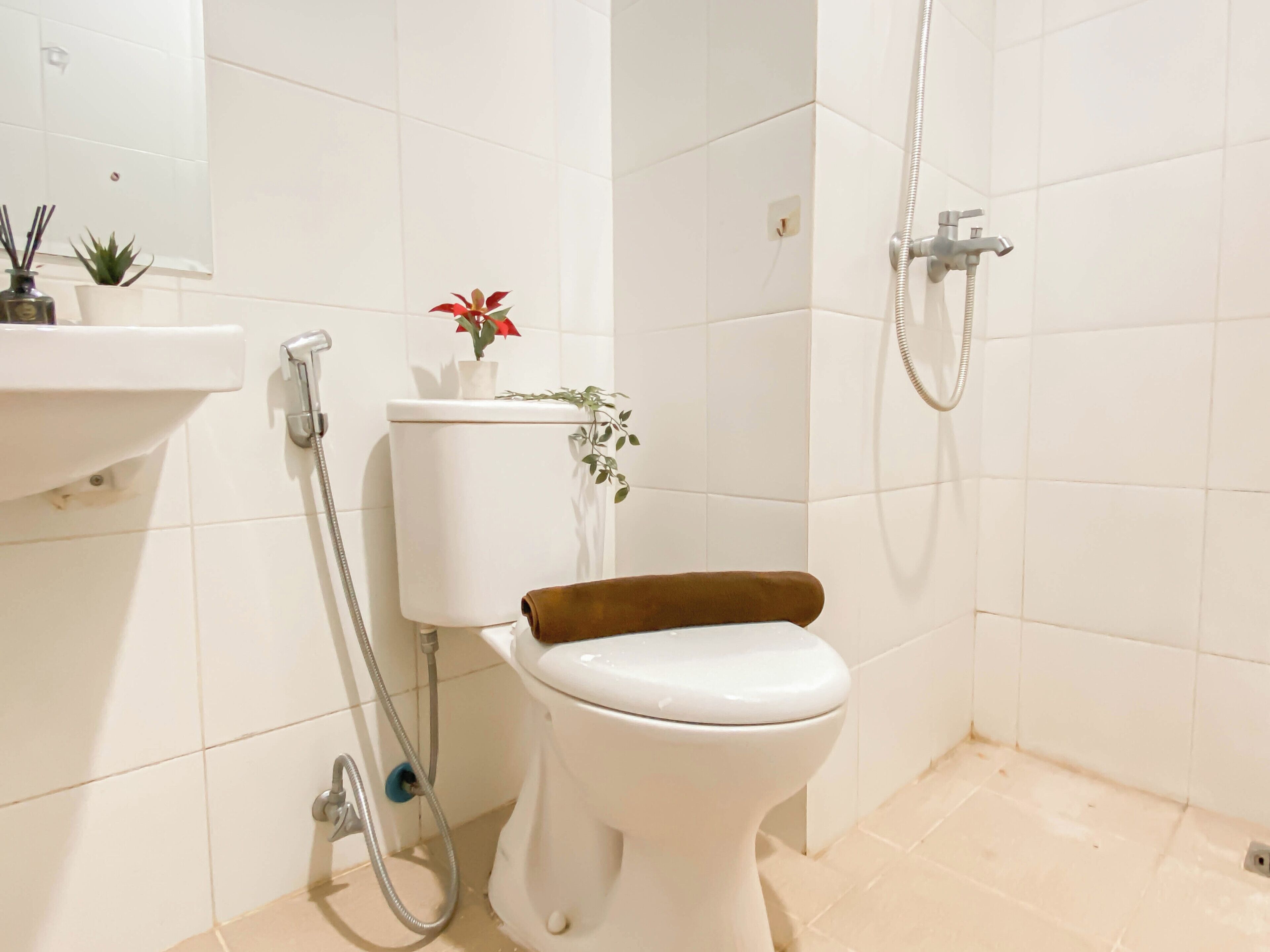 A bathroom with a toilet, a shower, and a sink.