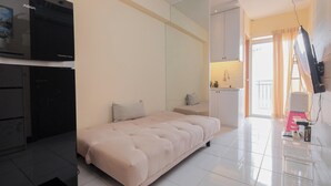 Ein Schlafzimmer mit einem Bett, einem Fernseher, einem Kleiderschrank und einem durchgegangenen Tür sichtbaren Badezimmer.