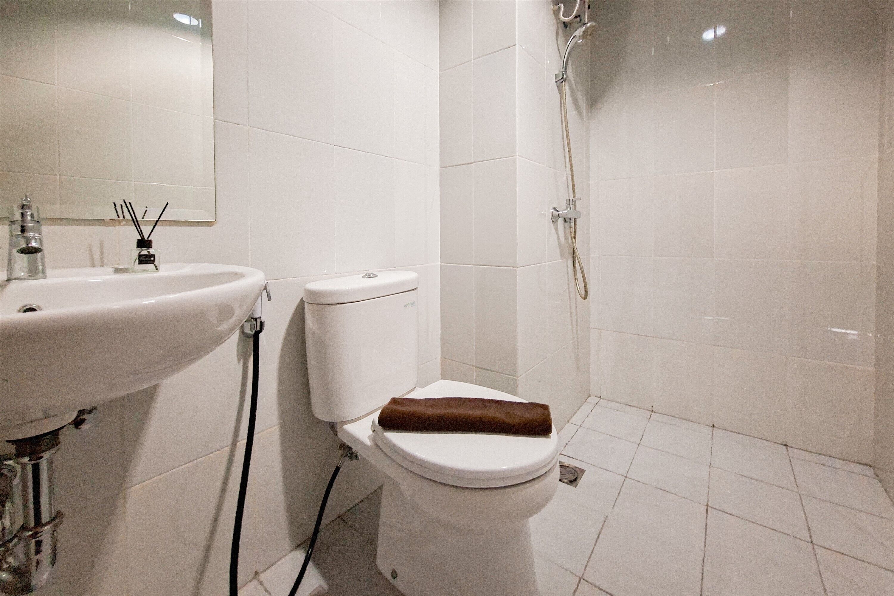 A bathroom with a white sink, toilet, and shower.