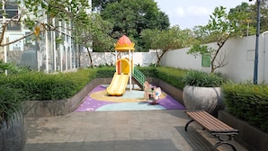 A playground with a yellow slide and a climbing structure. - Basic Studio Near Cisauk Station At Serpong Garden Apartment (Cisauk)