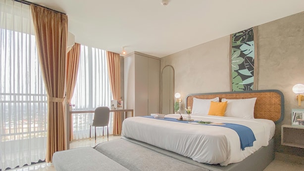 A hotel room with a bed, a desk, a chair, and a large window with curtains. - Modern Style Studio At Apartment Lrt City Bekasi (Bekasi)