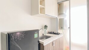 A modern kitchen with a built-in refrigerator, a sink, and a stove. - Chic 1Br Apartment At Vittoria Residence (Jakarta)