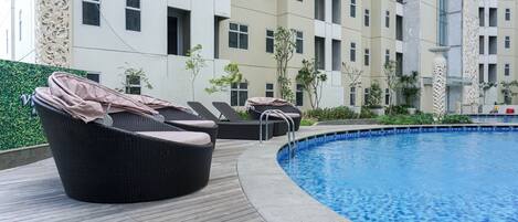A poolside area with lounge chairs and a swimming pool.