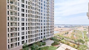 A high-rise building with multiple balconies and a view of a landscaped area with trees and a river. - Minimalist And Restful Studio At Tokyo Riverside Pik 2 Apartment (Teluknaga)