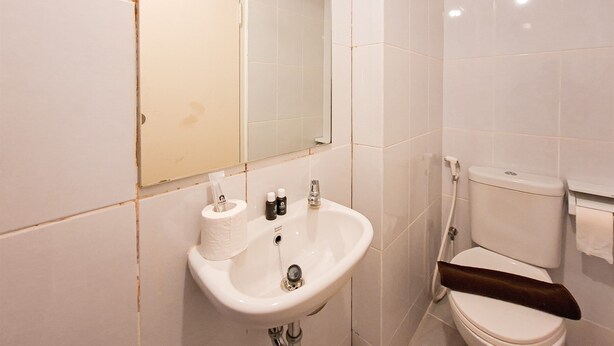 A bathroom with a sink, toilet, and mirror. - Minimalist And Restful Studio At Tokyo Riverside Pik 2 Apartment (Teluknaga)