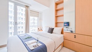 Une chambre à coucher moderne avec un lit, une table de chevet, un miroir et une armoire.