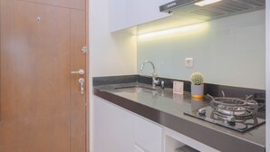 Una cocina moderna con un lavamanos de acero inoxidable, una estufa a gas y un horno empotrado.