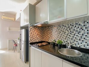 Deluxe Apartment | Private kitchen | Fridge, stovetop, rice cooker, cookware/dishes/utensils - White Toned Studio At Apartment Taman Melati Margonda (Depok)