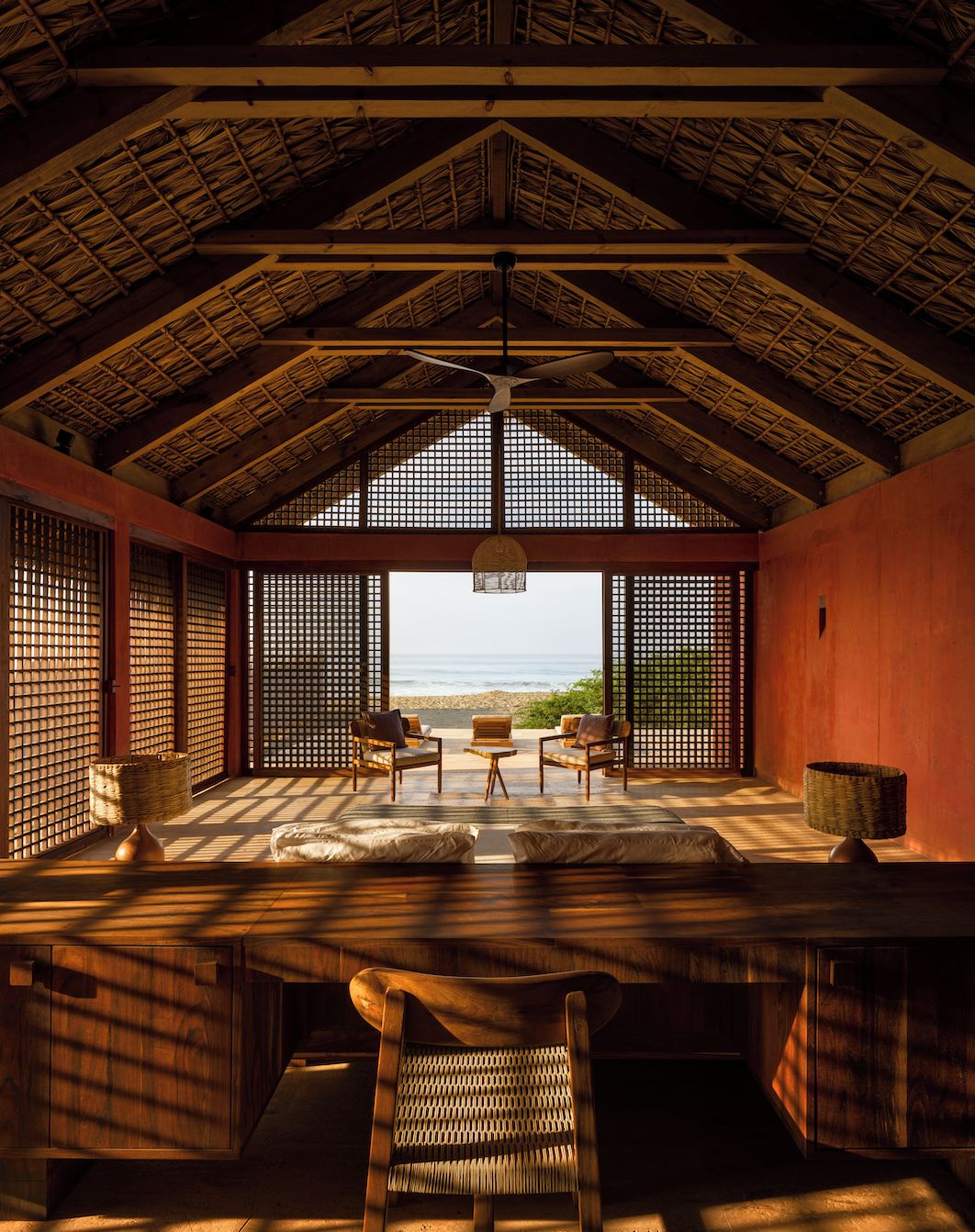 A room with a high ceiling, a view of the ocean, and traditional Japanese-style sliding doors.