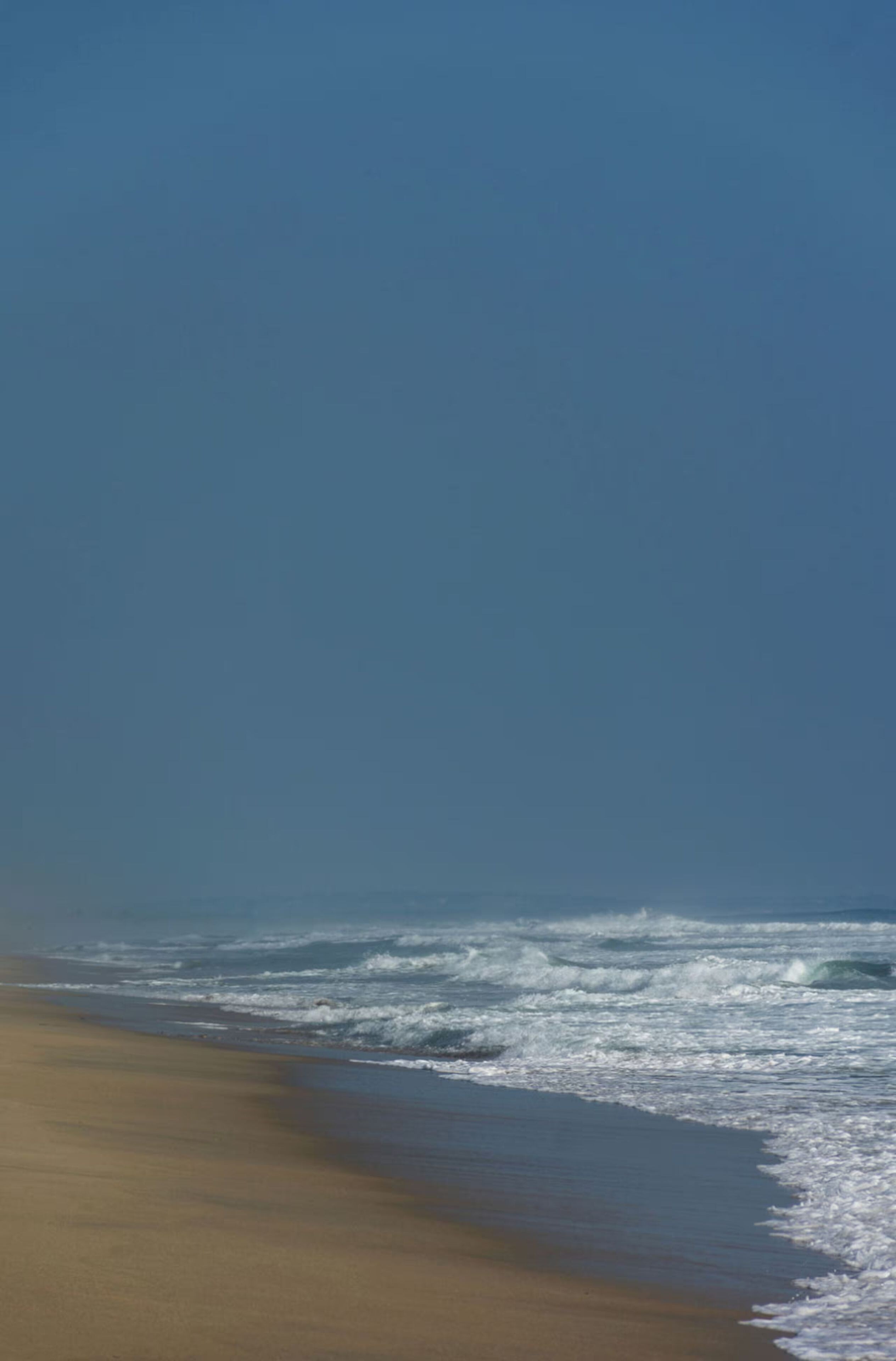 Una playa con olas acercándose a la orilla.