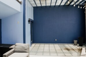 A room with a blue wall, a window, and a door. There is a light fixture on the ceiling.