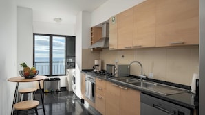Een moderne keuken met houten kastjes, een roestvrijstalen spoelbak en een ingebouwde vaatwasser.